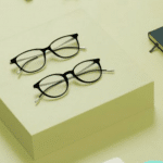 Two Moleskine eyeglass frames and a notebook on a green background
