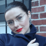Young woman bundled up in the cold weather, wearing rimless glasses