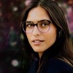 Lafont. eyeglass frames worn by a brown-haired model, showcasing October-inspired colours of brown and purple.